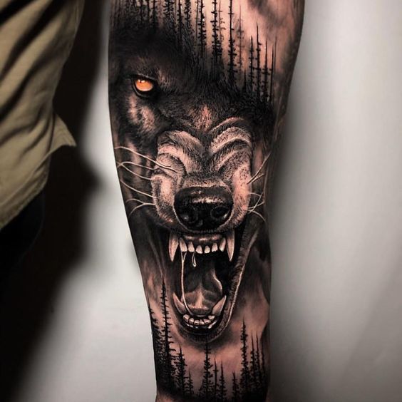 Tatuaż realistyczny wilka w lasie na przedramieniu