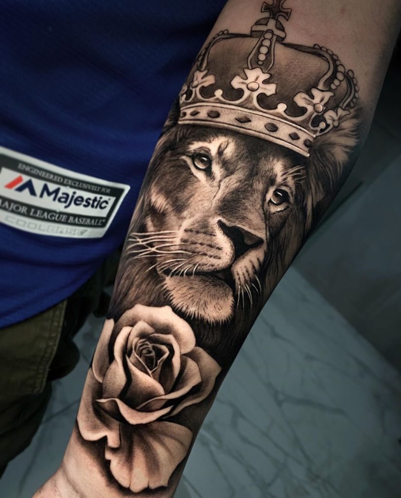 Tatuaż Lew z kwiatami różą i koroną na przedramieniu znaczenie dla mężczyzn i kobiet