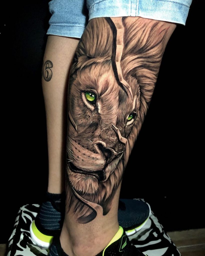 Tatuaż głowa lwa z kolorowymi oczami na łydce znaczenie dla mężczyzn i kobiet