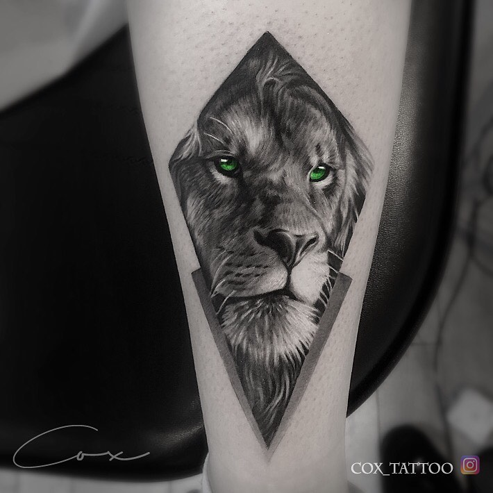 Tatuaż głowa lwa z zielonym oczami w rombie Znaczenie dla mężczyzn i kobiet