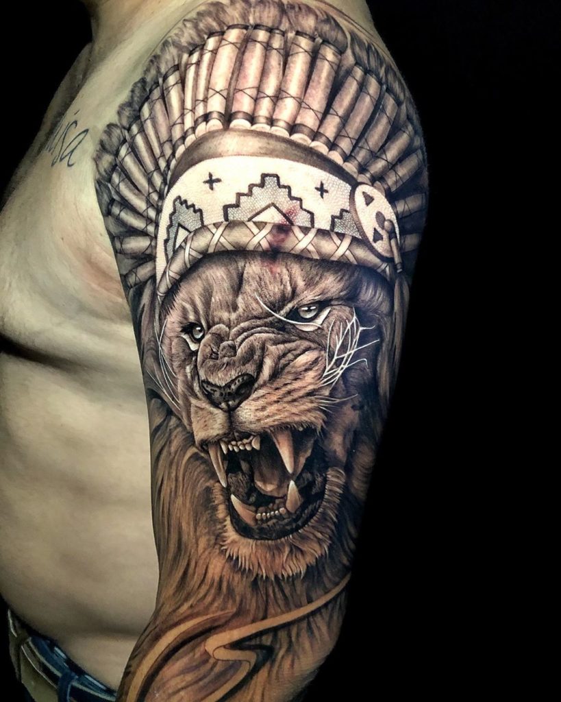 Tatuaż zły lew z piórami na głowie na ramieniu znaczenie dla mężczyzn i kobiet