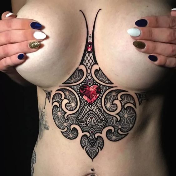 Tatuaż pod biustem, piersiami kobiece geometryczne z czerwonym diamentem