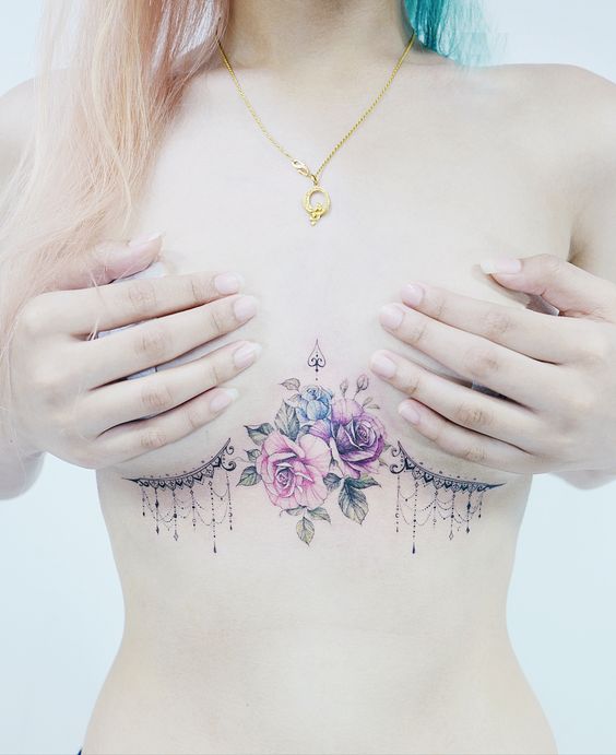 Tatuaż pod biustem, piersiami kobiece kolorowe róże