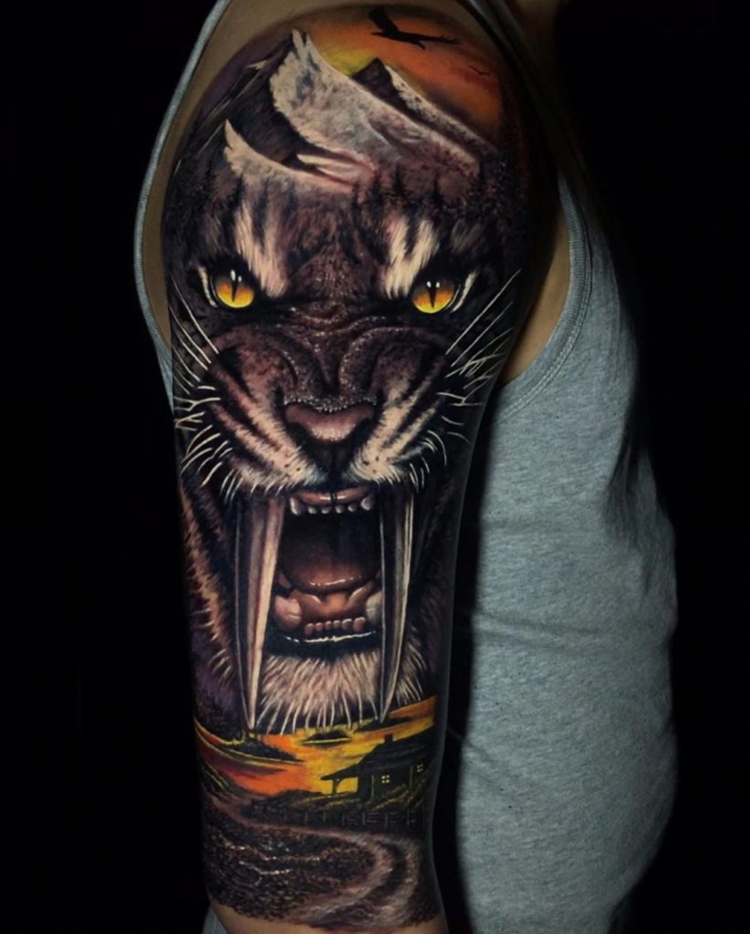 Tatuaż zły tygrys długimi zębami z żółtymi oczami na ramieniu dla mężczyzn i kobiet